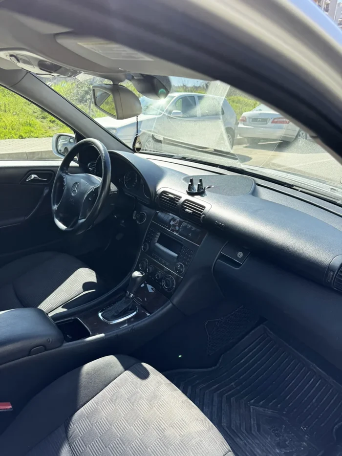 Front passenger seat and dashboard of 2007 Mercedes C-Class 2.2 CDI automatic saloon with dark upholstery