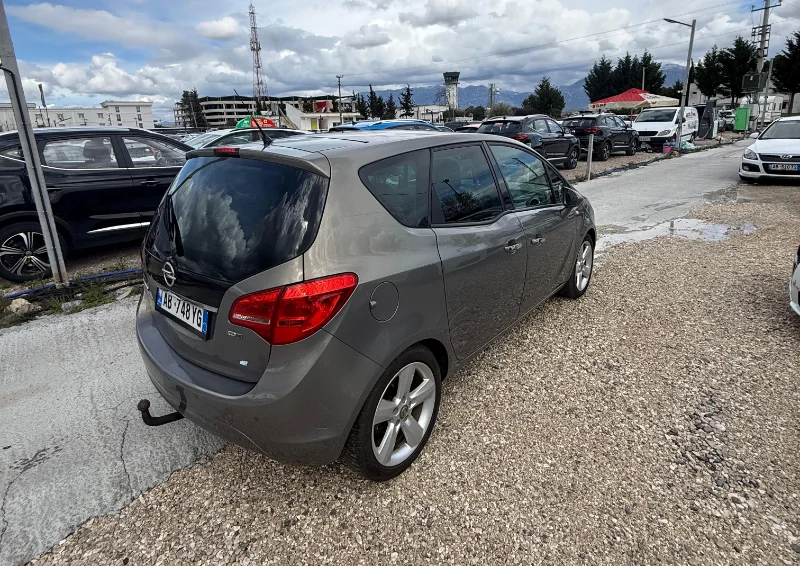Opel Meriva 2012 - 2.0 Diesel Manual 7 Seater with Panoramic Sunroof Rental in Tirana Albania 3 - Car Rent in Albania Grey Opel Meriva 2012 2.0 diesel manual compact MPV with panoramic sunroof and dark interior parked near Tirana International Airport Rinas